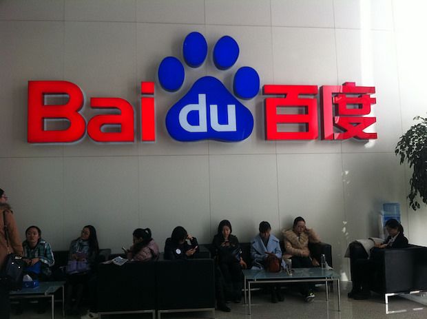 Baidu Logo an der Wand, darunter sitzen 8 Personen