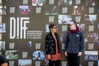 Dharamshala International Film Festival Plakat mit 2 Menschen davor