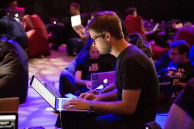 Person mit Laptop auf dem Schoß beim Swiss Blockchain Hackathon