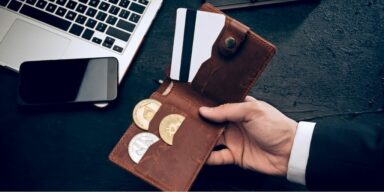 Portemonnaie mit Kryptos, Smartphone und Laptop