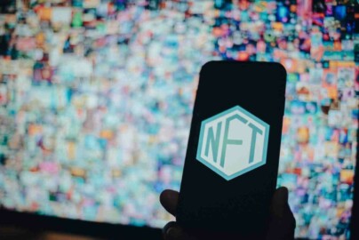 NFT Symbol auf Handy mit weiteren NFTs als Hintergrund