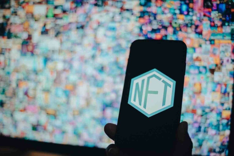 NFT Symbol auf Handy mit weiteren NFTs als Hintergrund