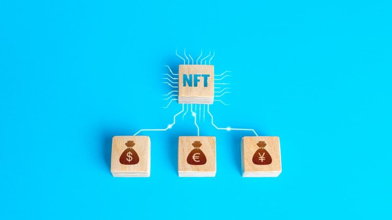 graphische Darstellung des NFT-Systems Holzwürfel mit den Aufschriften NFT, $, €