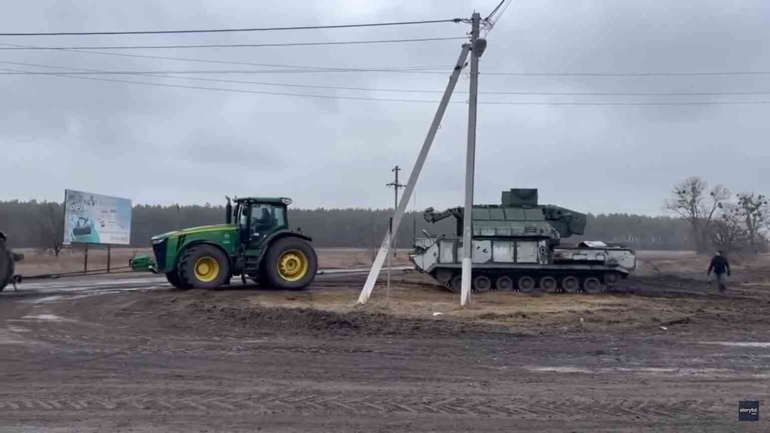 Traktor zieht einen Panzer über ein Feld