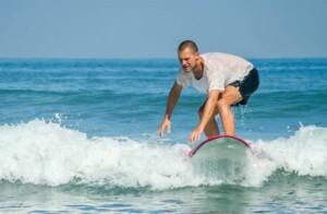 Mann surft im Meer Bali 