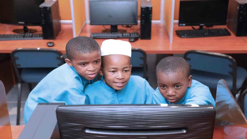3 Kinder schauen auf einen Monitor