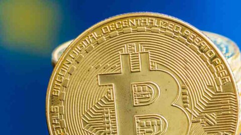 Bitcoin Münze EU Flagge im Hintergrund verschwommen