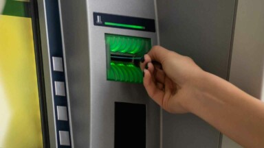 Bankkarte in Geldautomat von Hand gehalten