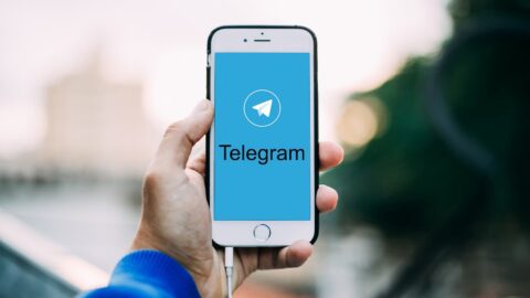 Hand hält Smartphone mit Telegram