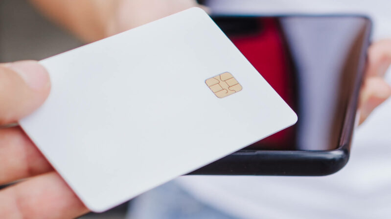 Kreditkarte weiss auf Handy für Zahlung in Kryptowährungen