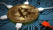 Goldene Bitcoinmünze mit weißen und roten Steckern