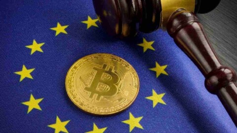 Goldene Bitcoin Münze auf Europaflagge Richterhammer