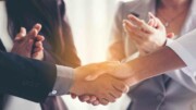 Business Partner schütteln Hände unter Applaus