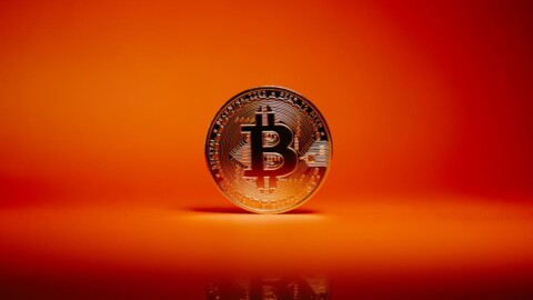 bitcoin münze vor rotem hintegrrund
