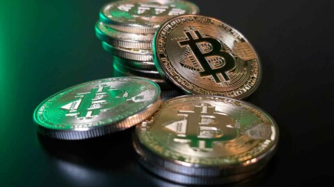 bitcoin m&uuml;nzen vor gr&uuml;nem hintergrund