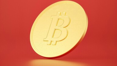 bitcoin münze vor rotem hintergrund