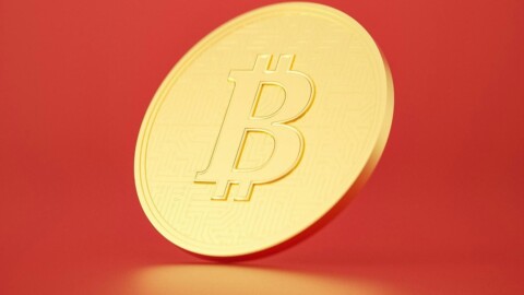bitcoin münze vor rotem hintergrund