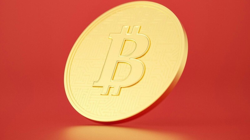 bitcoin münze vor rotem hintergrund
