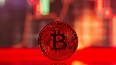 bitcoin münze vor rotem kurschart
