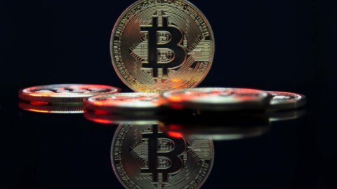 bitcoin münzen auf dunkler spiegelnder oberfläche