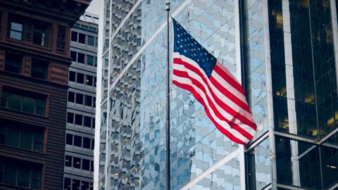 flagge der usa vor wolkenkratzern