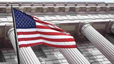 flagge der usa weht vor historischem gebäude