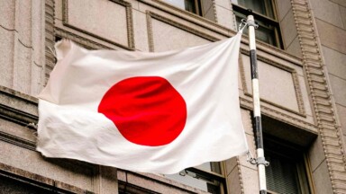 flagge japans weht vor hauswand