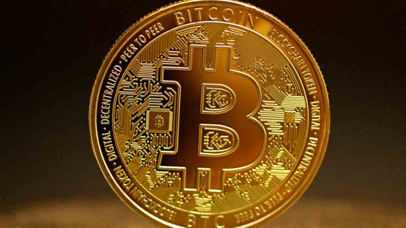 bitcoin münze steht vor dunklem hintergrund