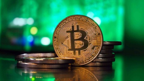 bitcoin münze vor grünem hintergrund