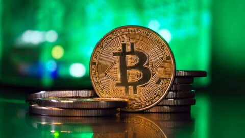 bitcoin münzen vor grünem hintergrund