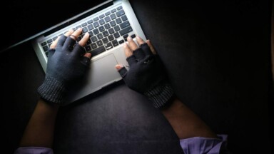 symbolbild hacker hände an einem laptop