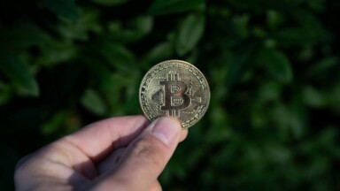 hand hält bitcoin-münze in die luft