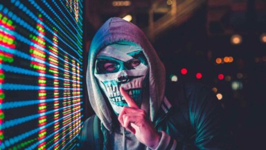 mann mit maske steht vor bildschirm