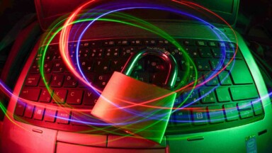 vorhängeschloss liegt auf computertastatur symbolbild hack
