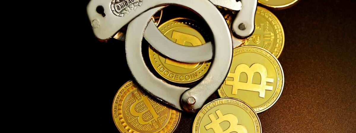 handschellen liegen auf krypto-muenzen