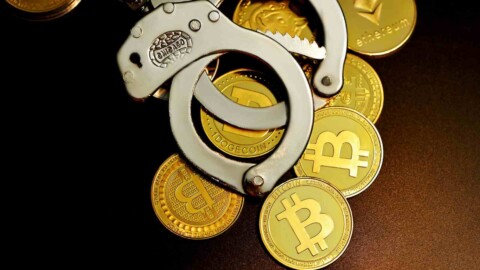 handschellen liegen auf krypto-muenzen