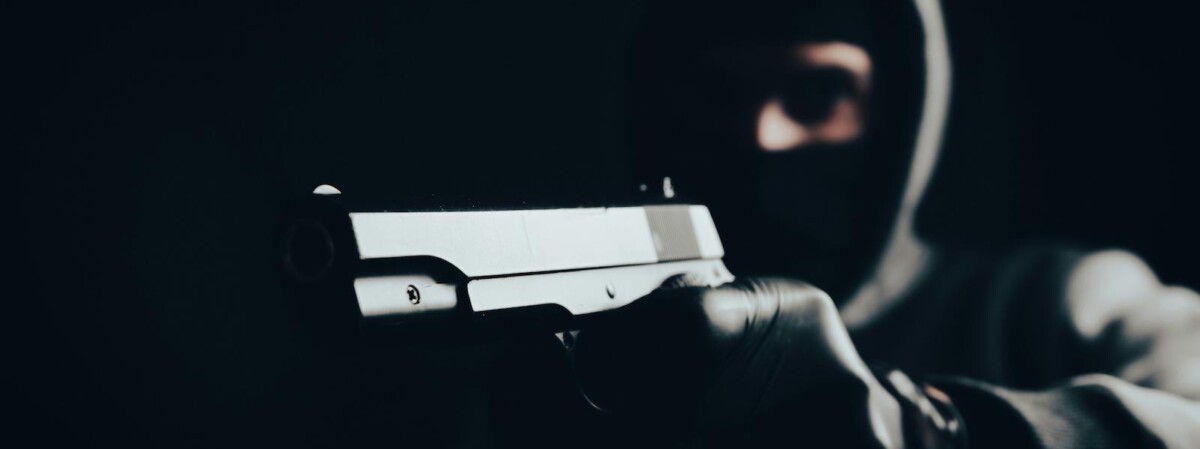 maskierter bankraeuber mit schusswaffe