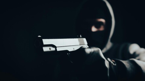 maskierter bankraeuber mit schusswaffe